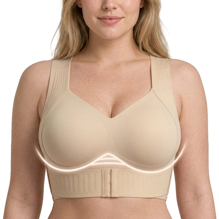 Kvinde iført en beige shaping-BH fra Kroppsbutiken med brede stropper, frontlukning og diskret markering under brystet.