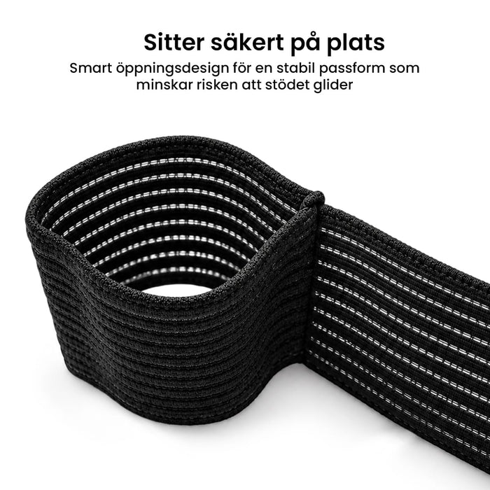 Elastisk albuebandage med hvid søm, sammenrullet, med svensk tekst om sikker og stabil pasform.