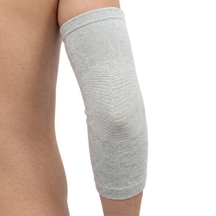 En person har en albuebandage i bambus fra Kroppsbutiken på albuen som støtte ved daglige aktiviteter.